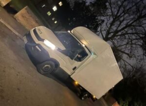 white luton van parked on road with the headlights on