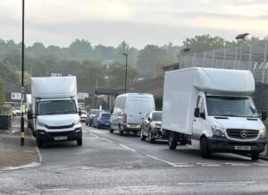 two white luton vans parked at a junction